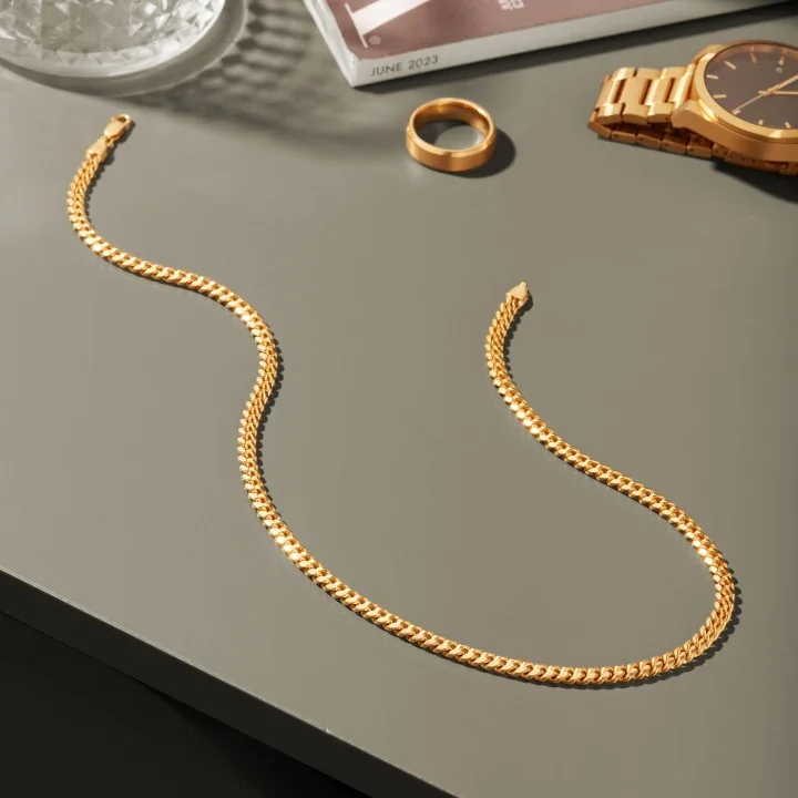 The chain laid out beside a gold watch and a ring